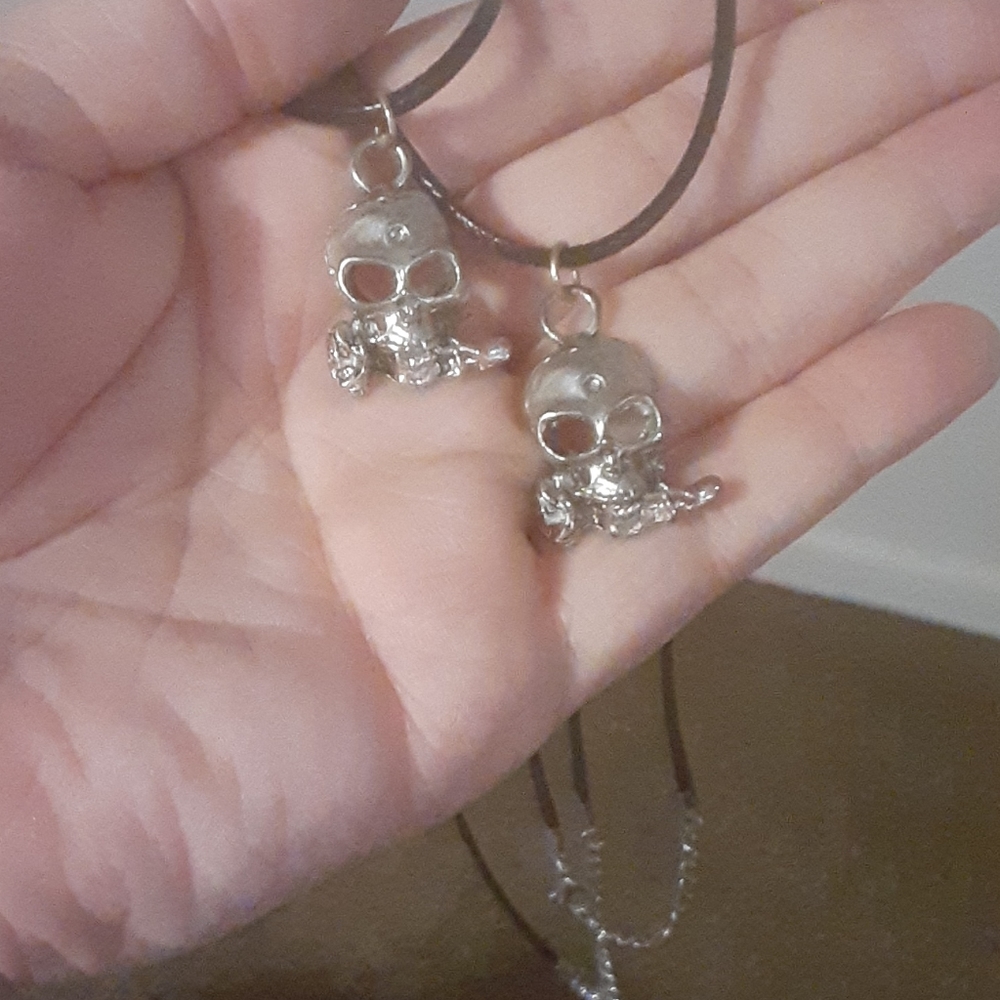 2 metal skull necklaces with rose in mouth
